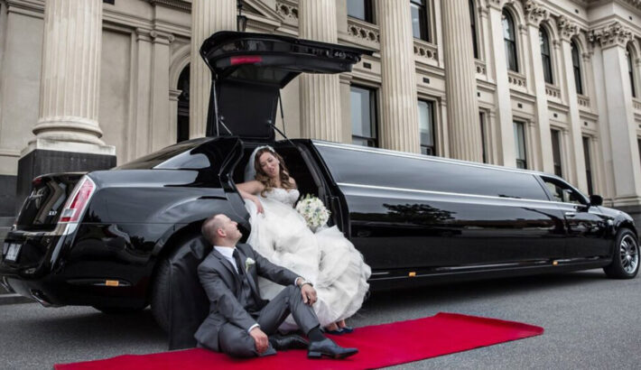 Bride and groom posing infront of a luxury car